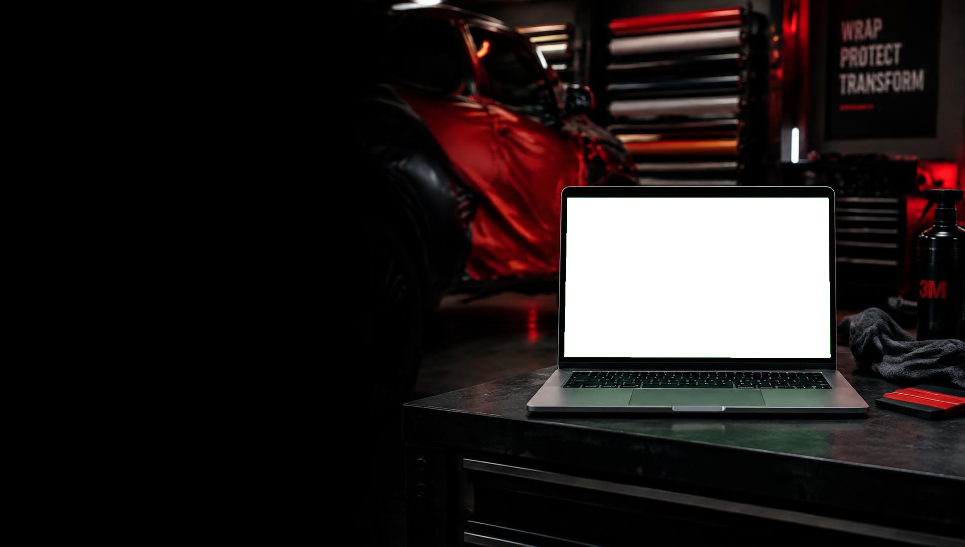 Laptop on a workbench in a vehicle wrap shop